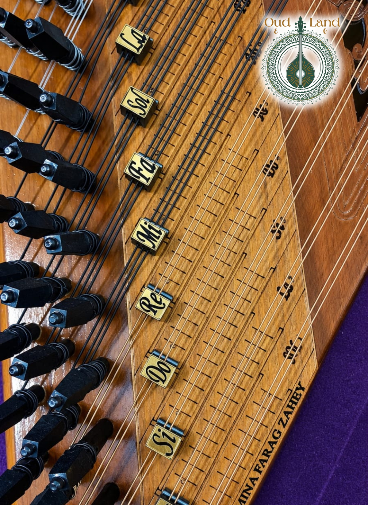 Microtonal mandal levers and wooden solfège note markers (Do, Re, Mi) on a Qanun soundboard.